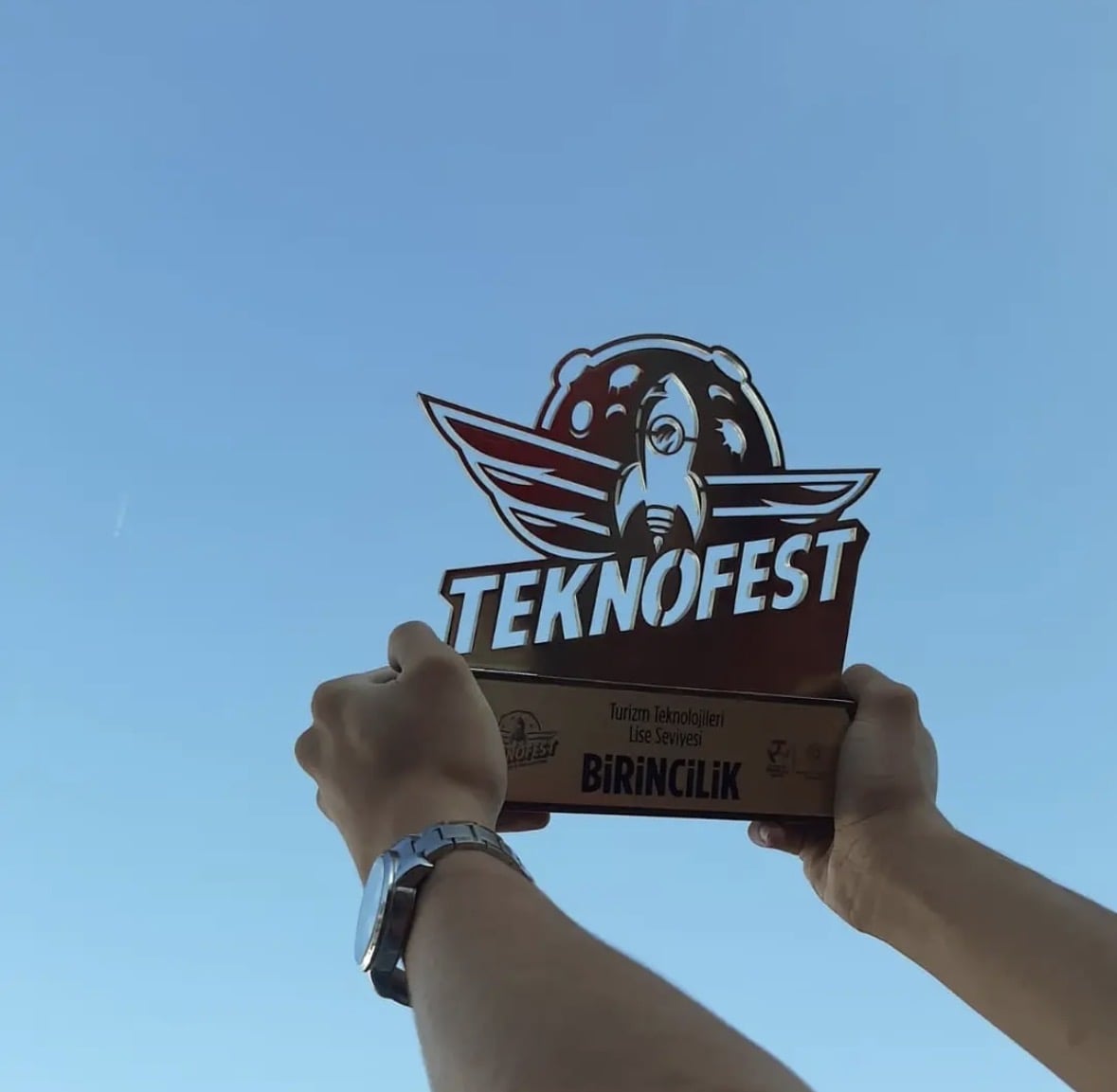 The Mobil Çelebi first-place TEKNOFEST trophy raised against the sky