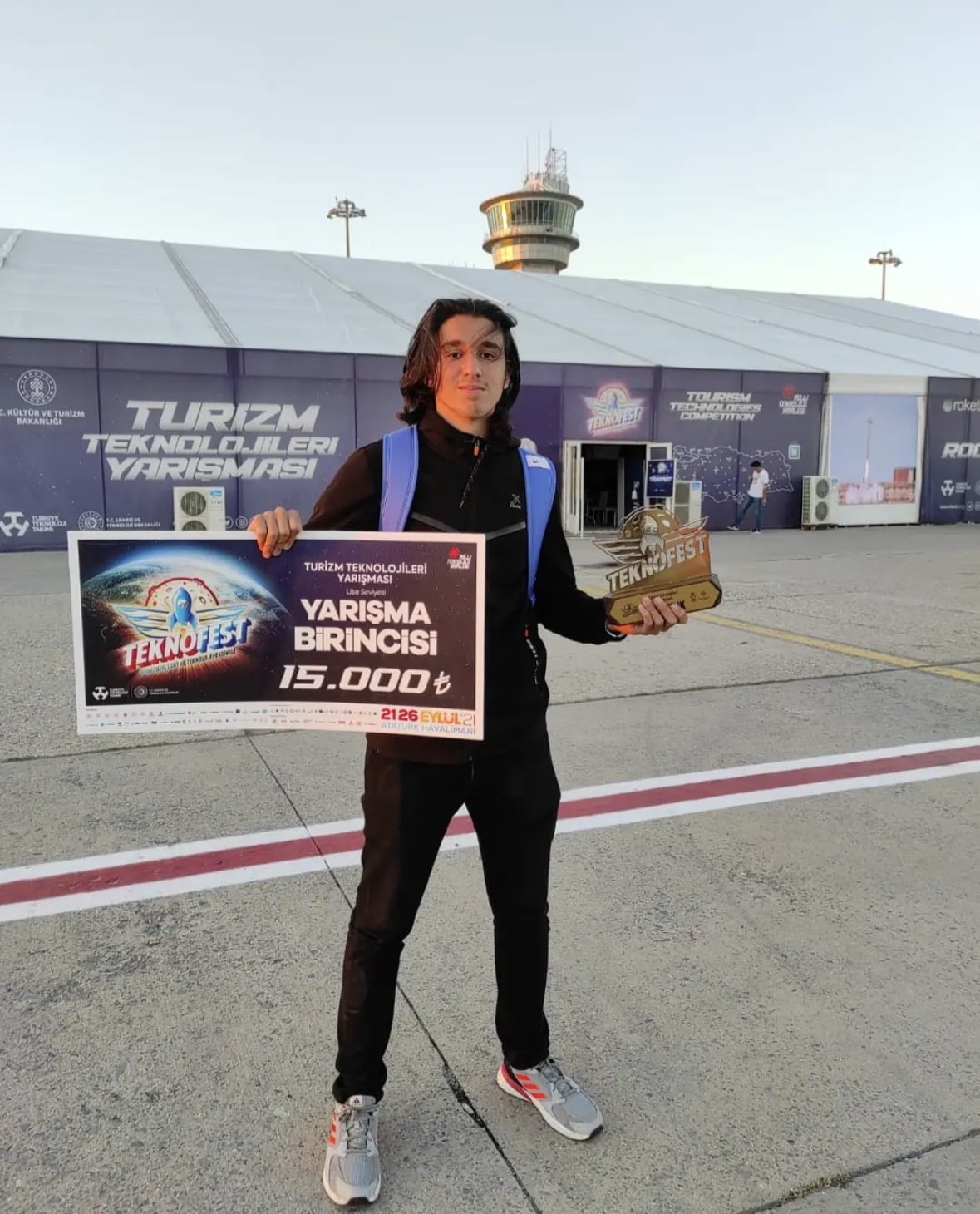 Ibrahim holding the first-place award and trophy at TEKNOFEST