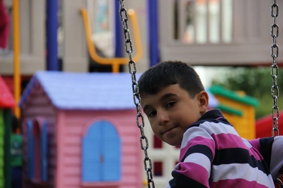 Ibrahim on a swing during his primary school years